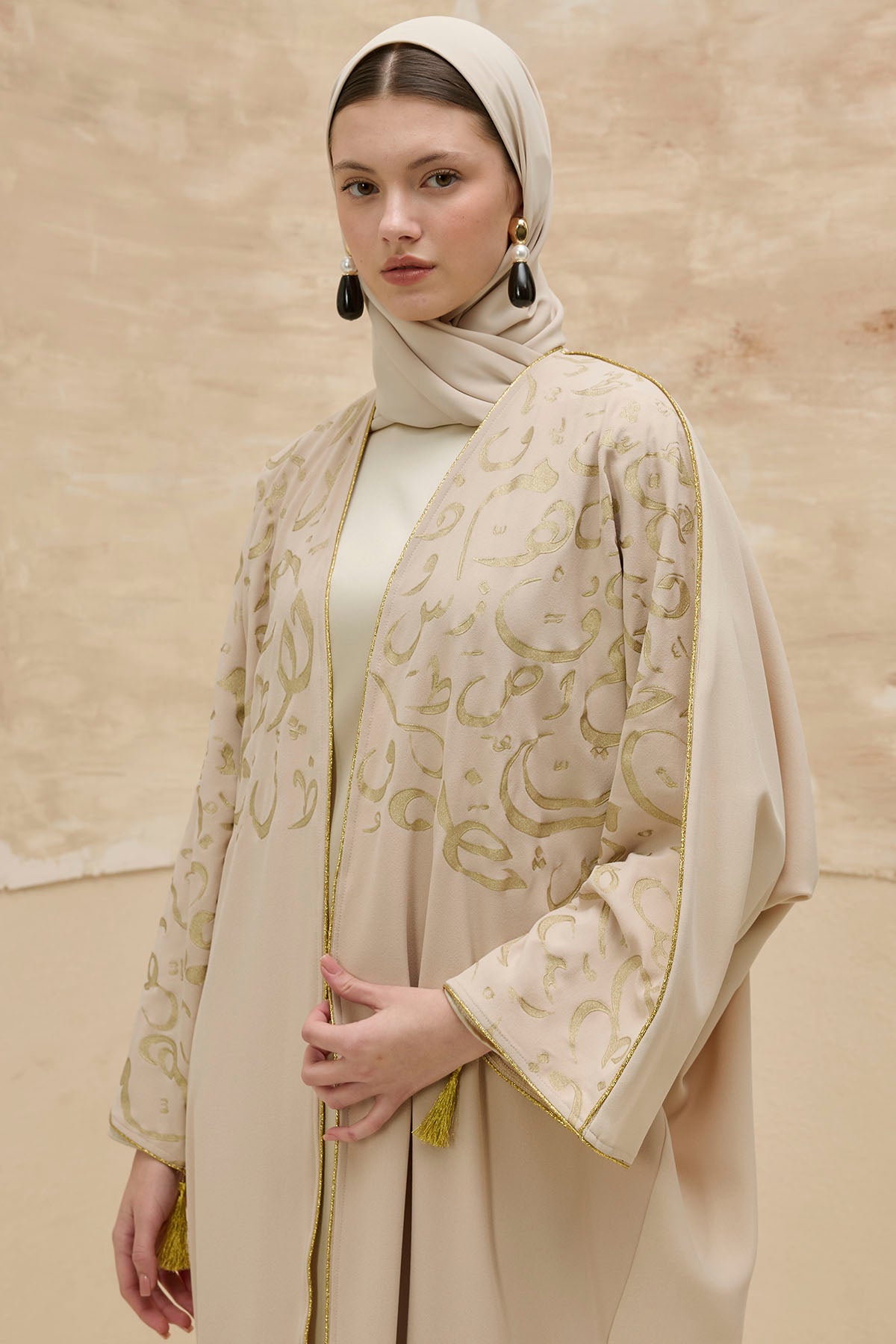 Kaligrafik Desenli Üst Form Omuz ve Kol Biyeli Uzun Taş Abaya